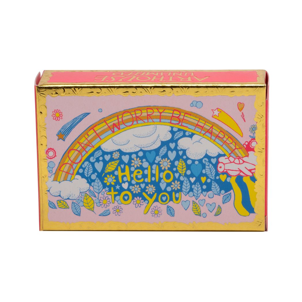 Rectangular soap in packaging with gold embossed card around the edges. The Illustration shows a rainbow and clouds with text in red inside the rainbow reading: Don't Worry Be happy. Yellow text below the rainbow says: Hello to you.