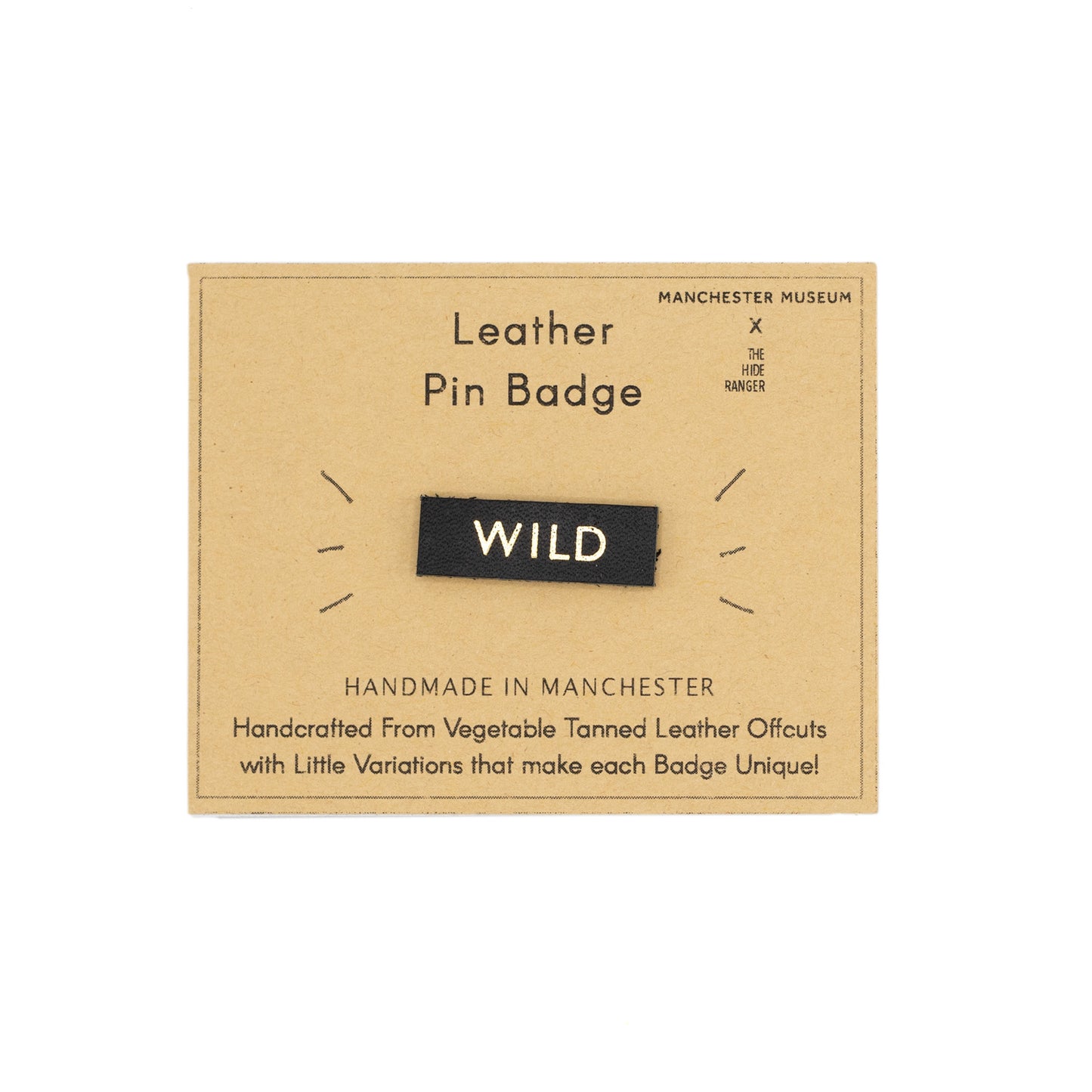 Leather pin badge with the word WILD, photographed against brown backing card.