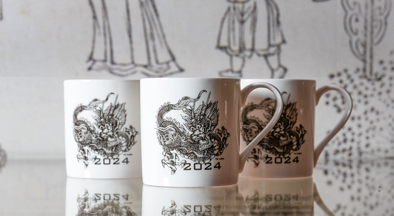 Three mugs sad side by side, each with an illustration of a dragon