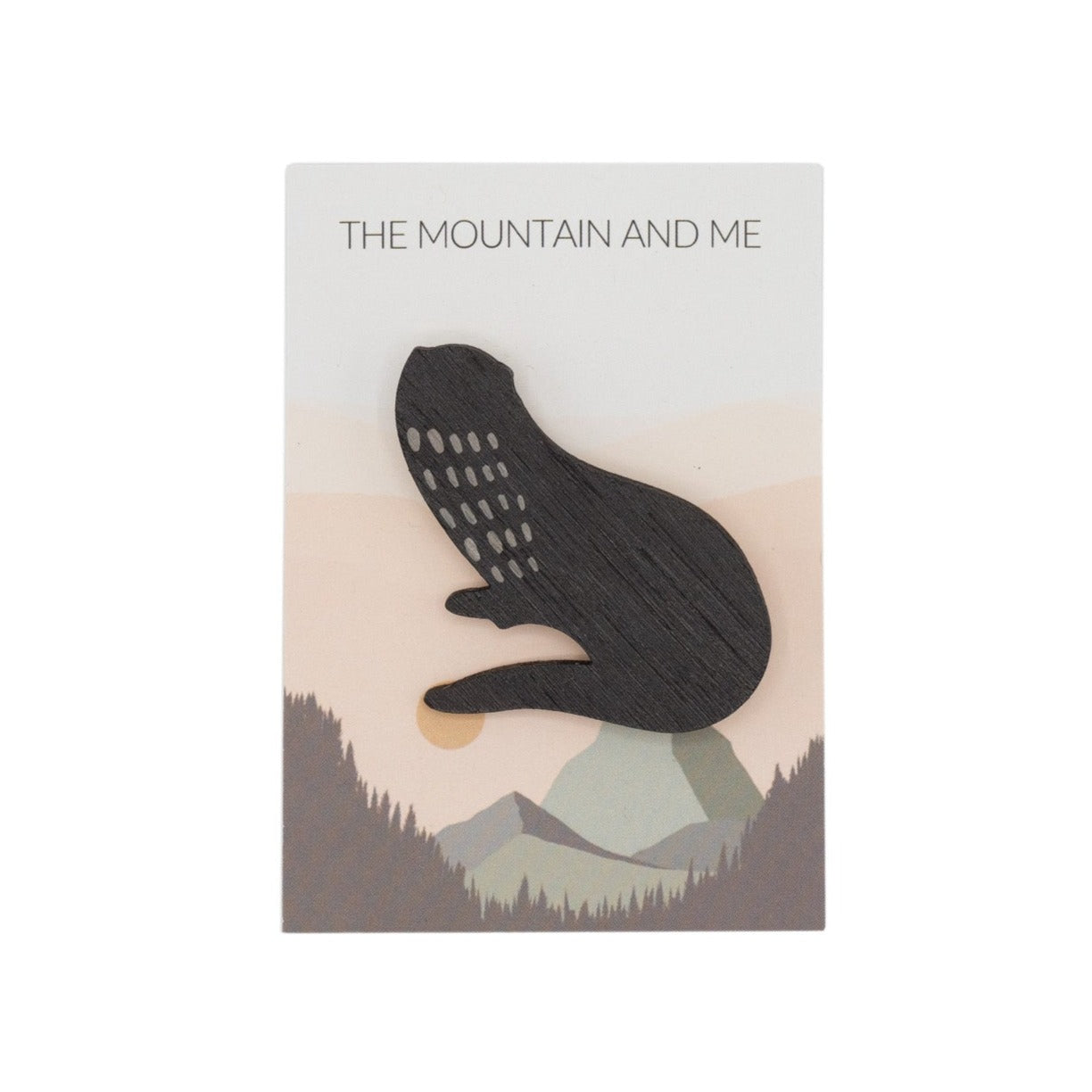 Wooden brooch in the shape of an otter against a branded Mountain and Me backing card