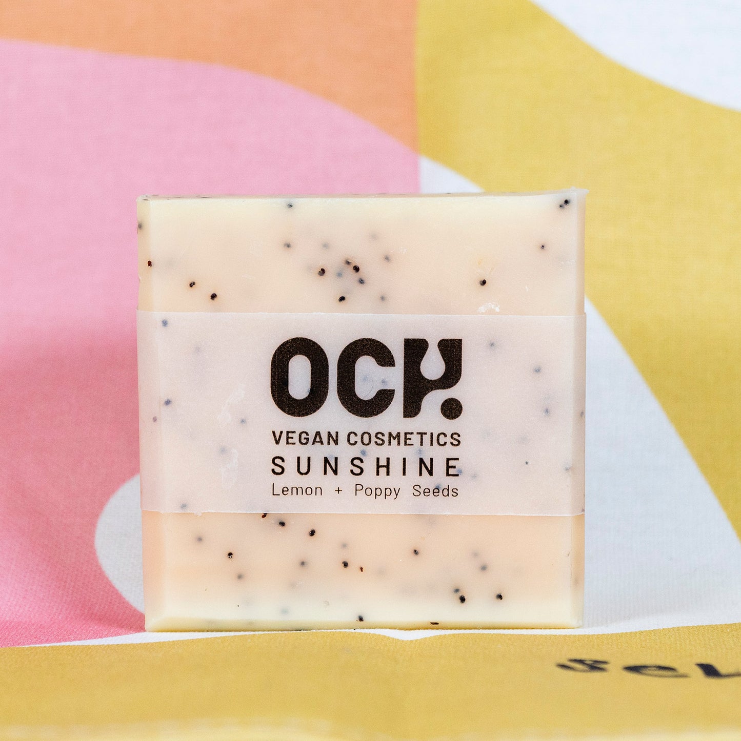 Cream coloured soap presented in front of a colourful backdrop.