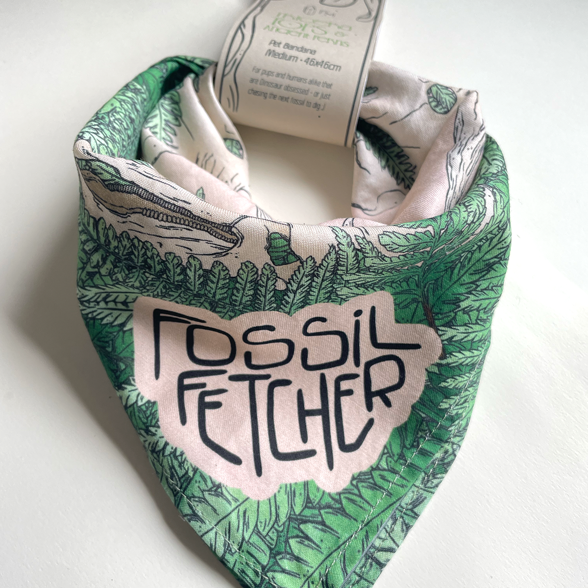 Dog bandana with 'Fossil Fetcher' text and leaf pattern on a white background