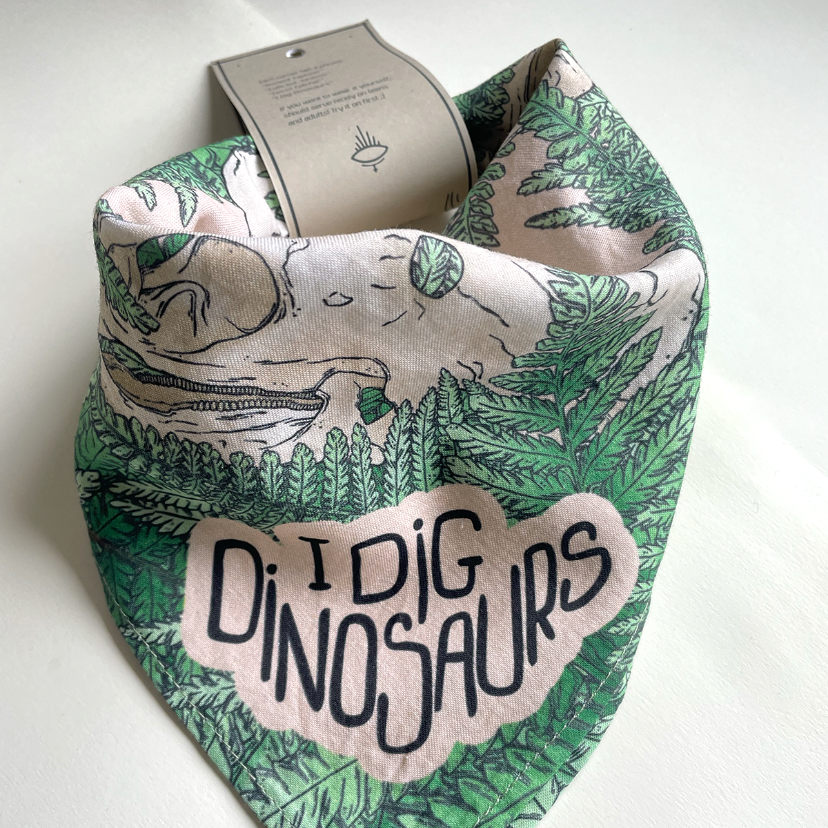 Dinosaur-themed bandana with 'I Dig Dinosaurs' text on a white background