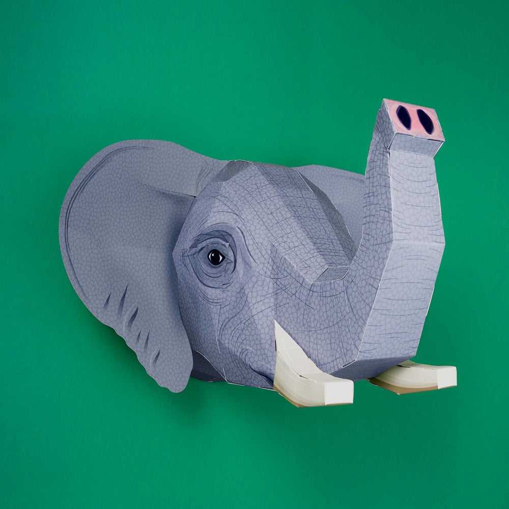 The assembled elephant head in a three-quarter angle against a green background. The trunk is raised.