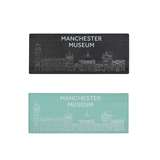 Black and turquoise bamboo magnets on a white background. The black with white print and text is on the top. The museum facade is across the bottom of each magnet with the text, Manchester Museum, above.
