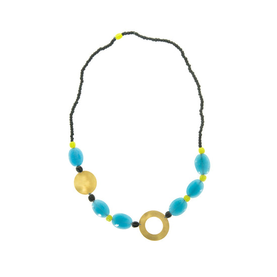 Necklace with small green beads around the neck end and larger blue and yellow beads along the drop. There is a brass disc to the left and a brass circle with a cut out just off centre of the drop.