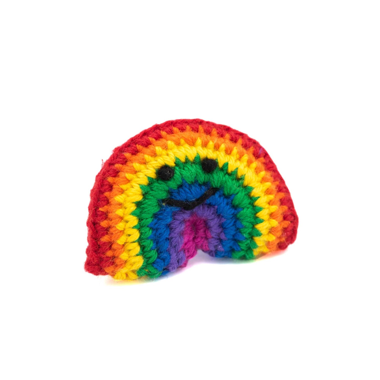 Crochet rainbow brooch with a little smiley face in black thread.