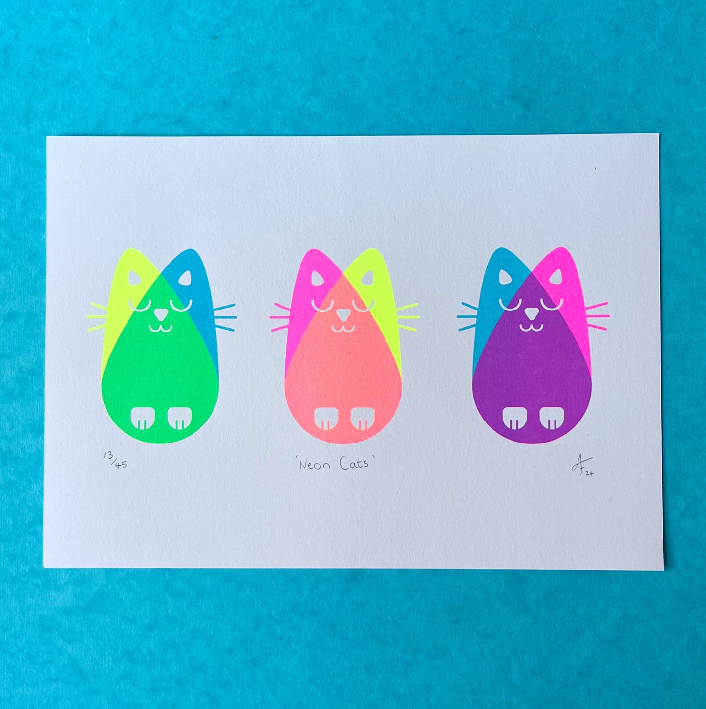 Three nean cats print on a blue background.