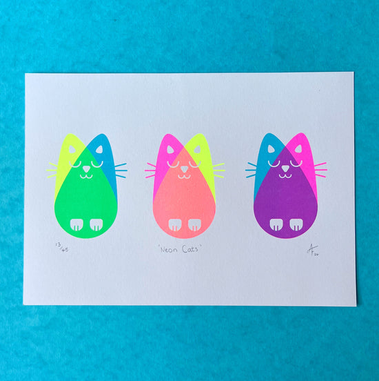 Three nean cats print on a blue background.