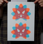Two colorful dinosaur head illustrations on a white A4 print held by a person.