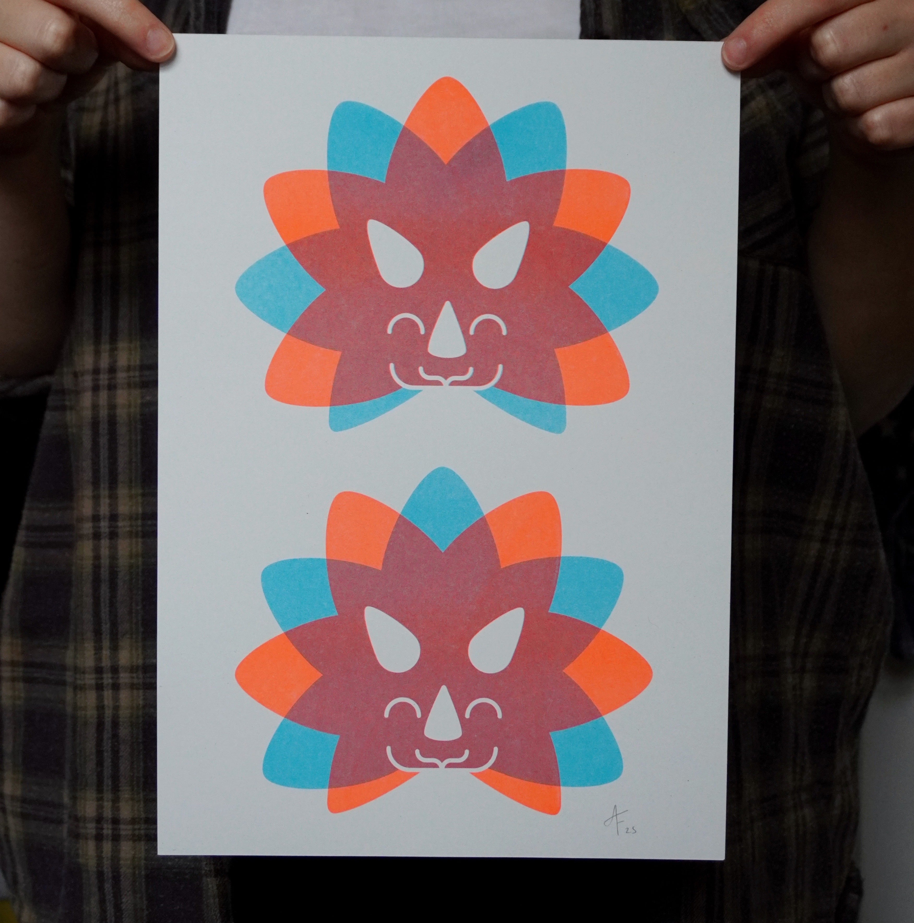 Two colorful dinosaur head illustrations on a white A4 print held by a person.