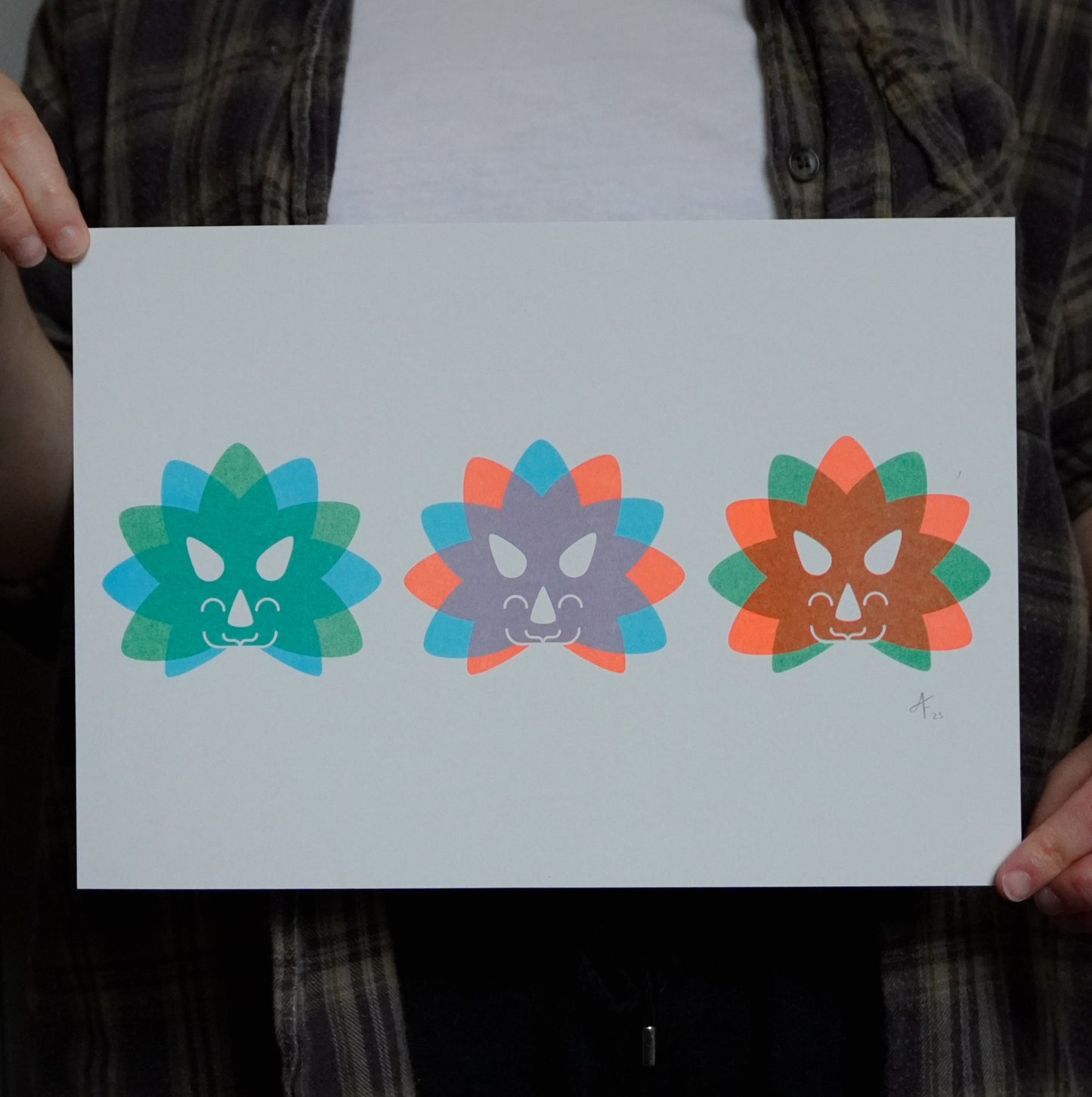 Three colorful Triceratops head designs held by a person.