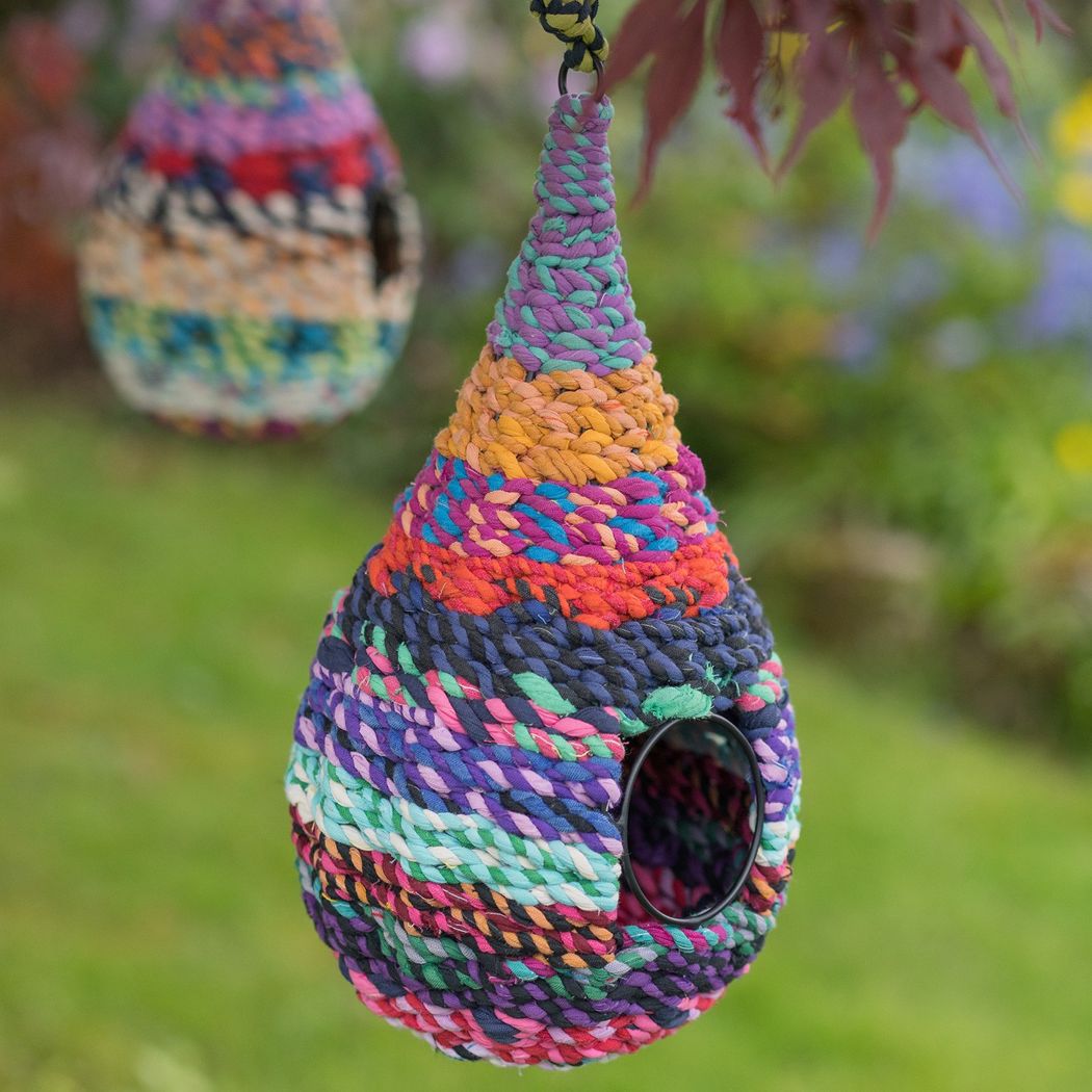 Colourful sari birdhouse in teardrop shape with a side opening.