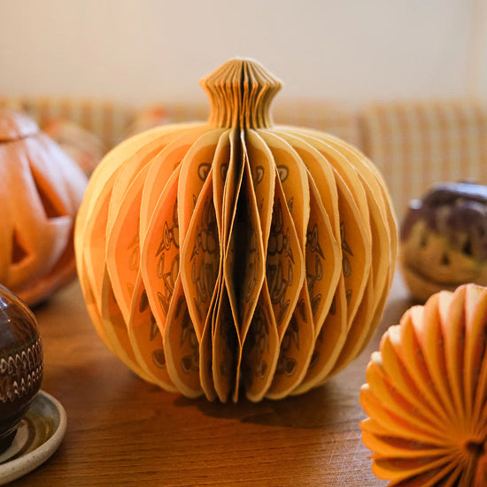 Decorative paper pumpkin on a wooden surface.