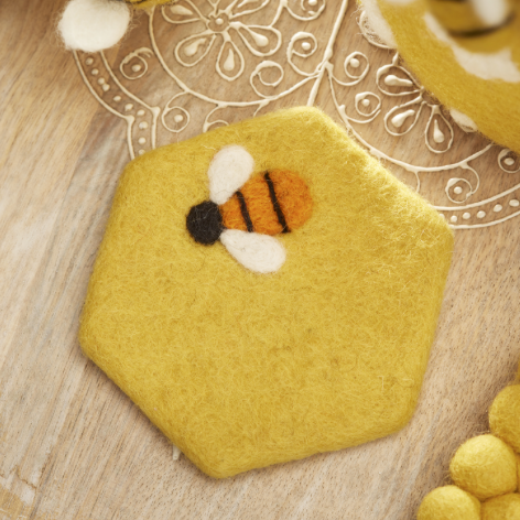 Yellow felt hexagonal coaster with a felt bee.