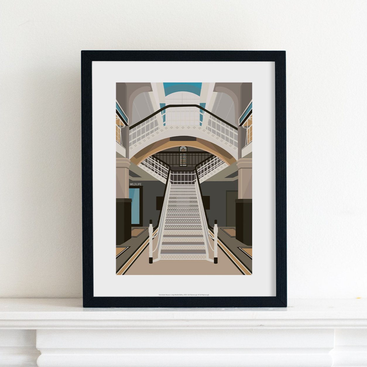 Print illustration of of the Living Worlds gallery at Manchester Museum, placed in a black frame on top of a mantelpiece.