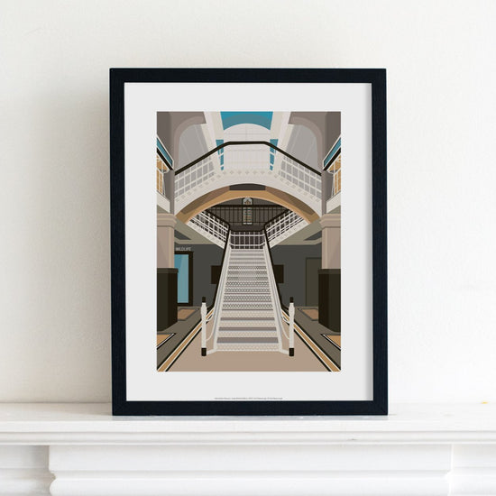 Print illustration of of the Living Worlds gallery at Manchester Museum, placed in a black frame on top of a mantelpiece.