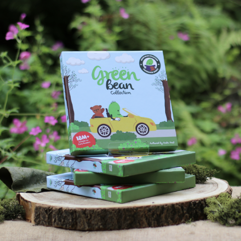 Front cover of box packaging for a series of books. Photographed in front of greenery.