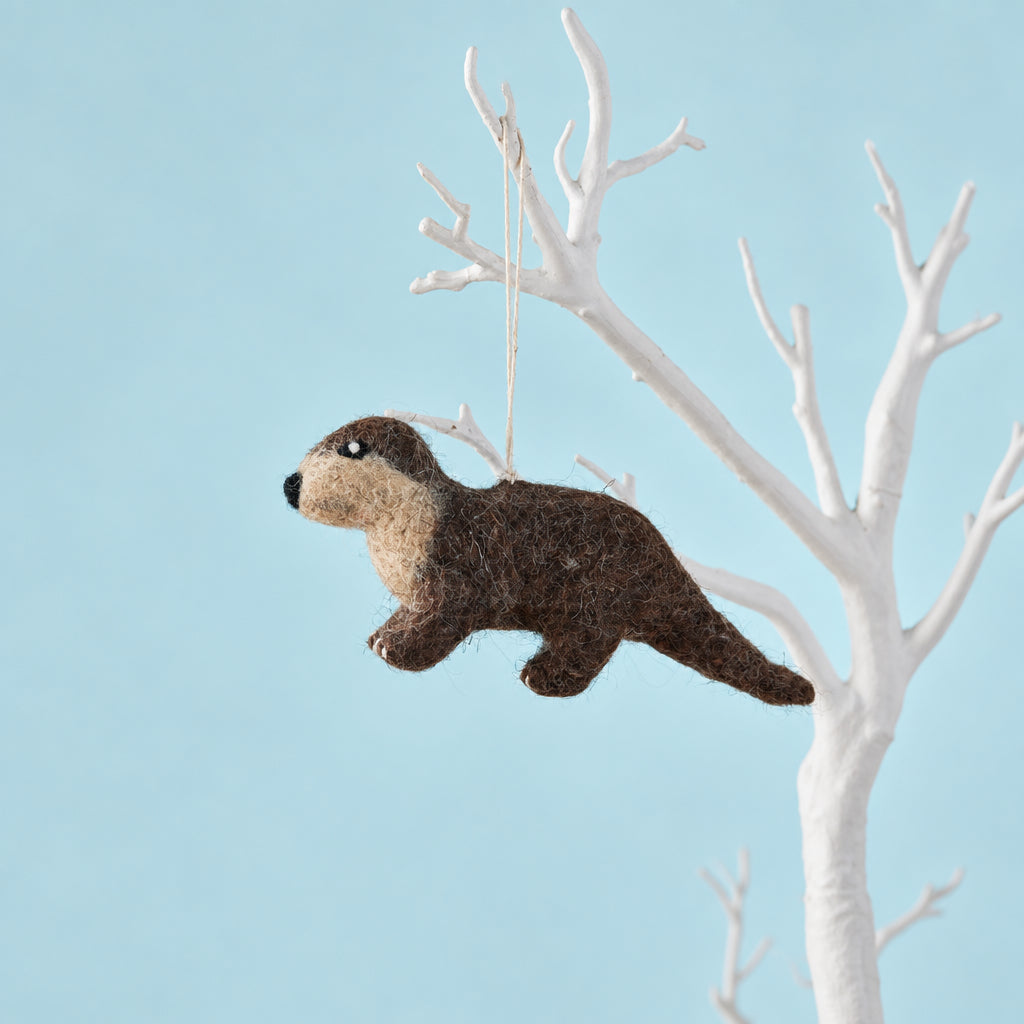 Handmade wool felt otter decoration with brown fur, small legs and a long tail, suspended from a white hanging loop.