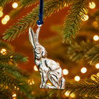 Silver sitting hare hanging decoration handcrafted from recycled aluminium and suspended from a blue velvet thread.