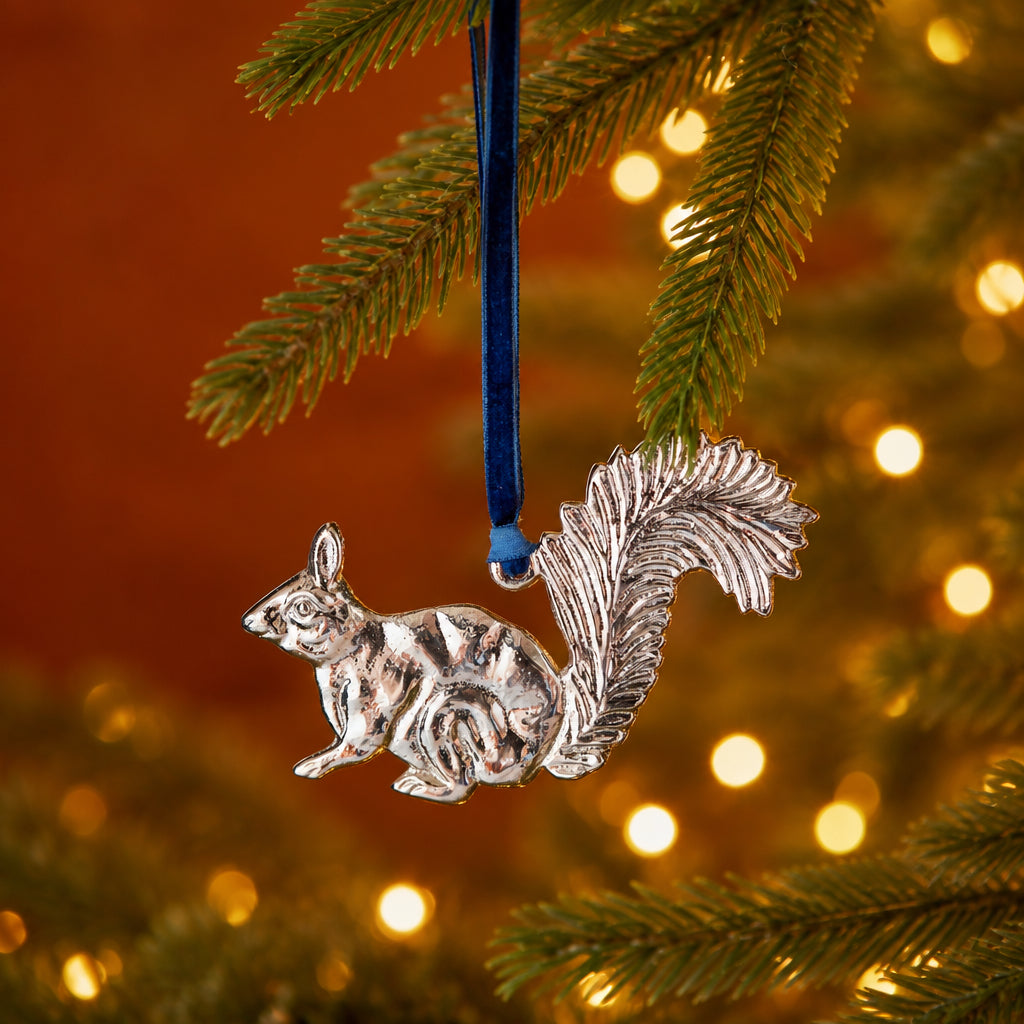 bushy-tailed squirrel decoration is made from recycled aluminium and hangs from a blue velvet thread.