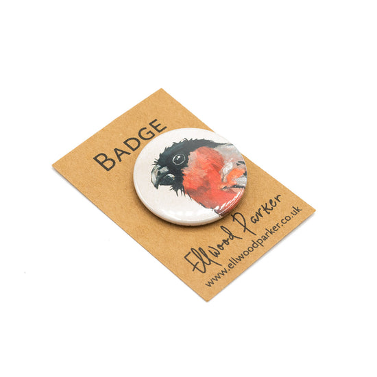 Badge with an illustration of a bullfinch against branded backing card.