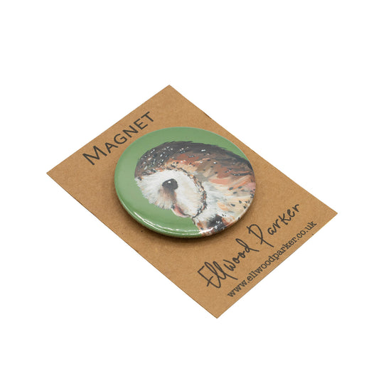 Photo of a round magnet with a barn owl illustration on it.