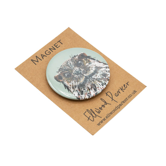 Round magnet with a otter illustration on it.