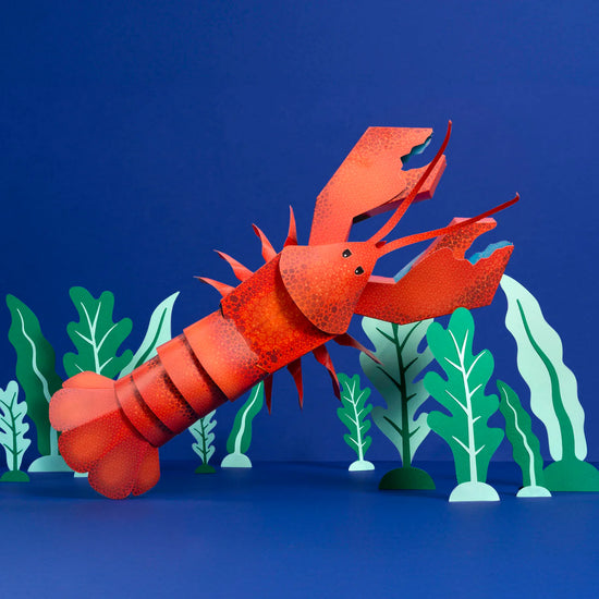 A lobster made out of card in front of a blue background