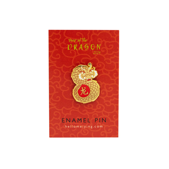 Gold pin in the shape of a dragon photographed on Lydia Leiying red branded backing card