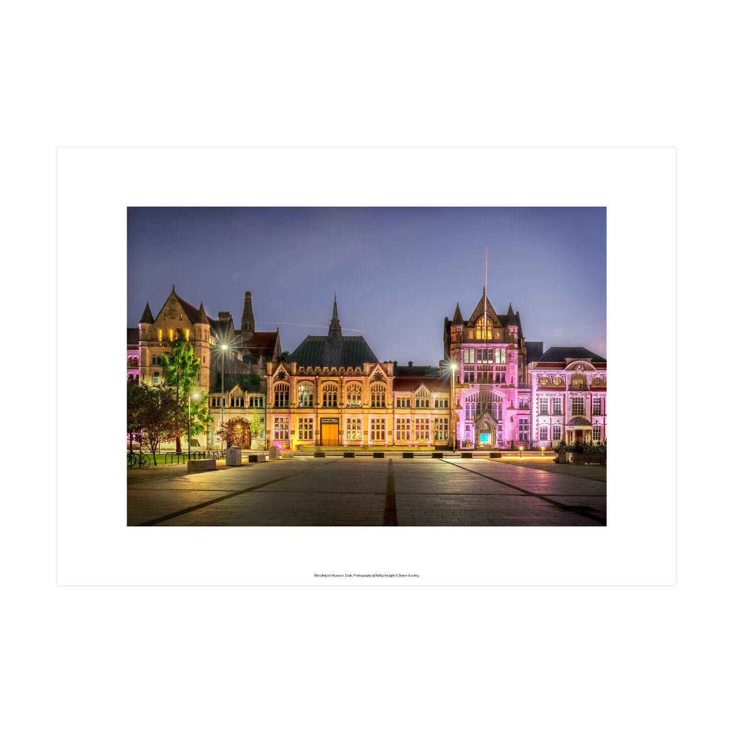Photograph of the Manchester Museum's front at dusk with purple  and warm yellow lights across the facade.