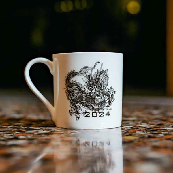 Mug with an illustration of a dragon photographed on a speckled marble surface