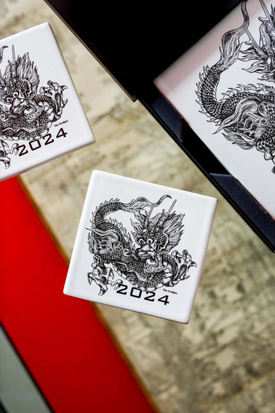Square coaster with a dragon on it.