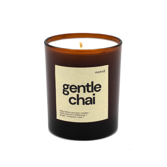 Soy wax candle in a brown glass jar with a label with the word's "gentle chai".