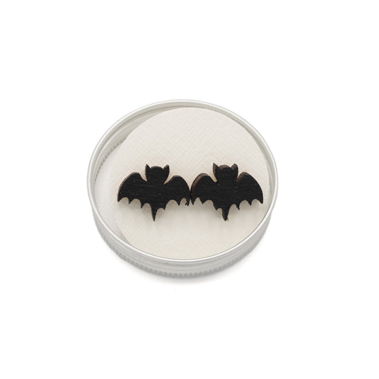 Earrings in the shape of a bat in a circular tin lid