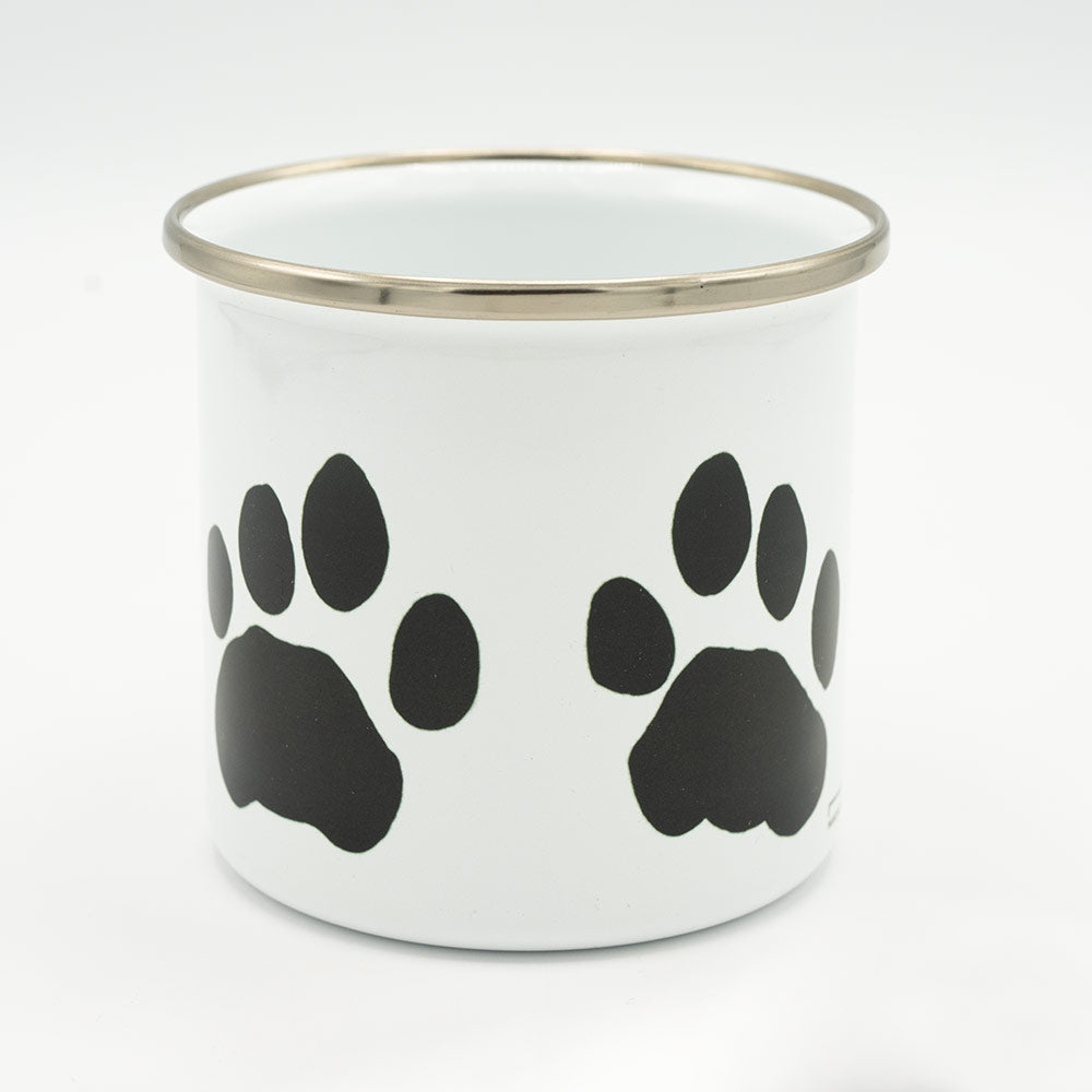 White mug with black paw prints and a silver rim on a white background