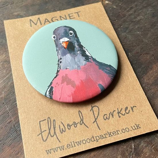 Lifestye photo of a round magnet with a pigeon illustration on it.