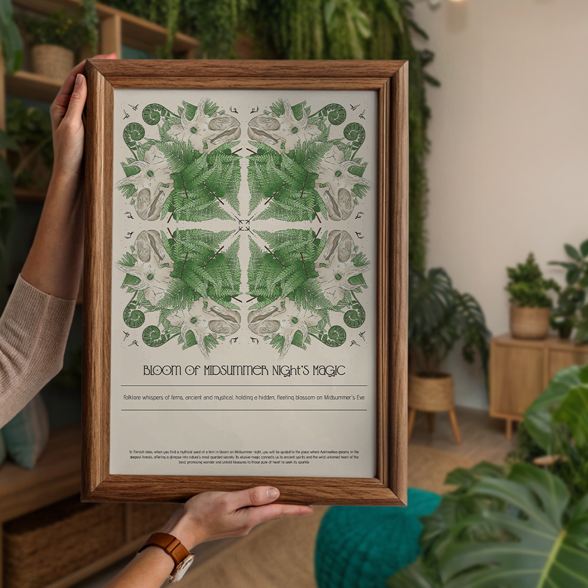Framed artwork with green leaf pattern held by a person in a room with plants.