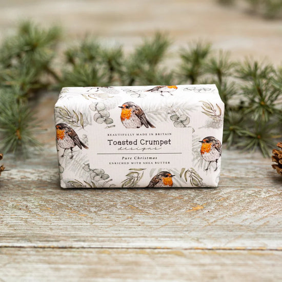 Soap bar with robin print packaging, presented on a wooden surface