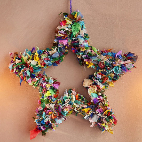 Wreath in star shape made from offcuts of recycled saris in various colours and patterns.