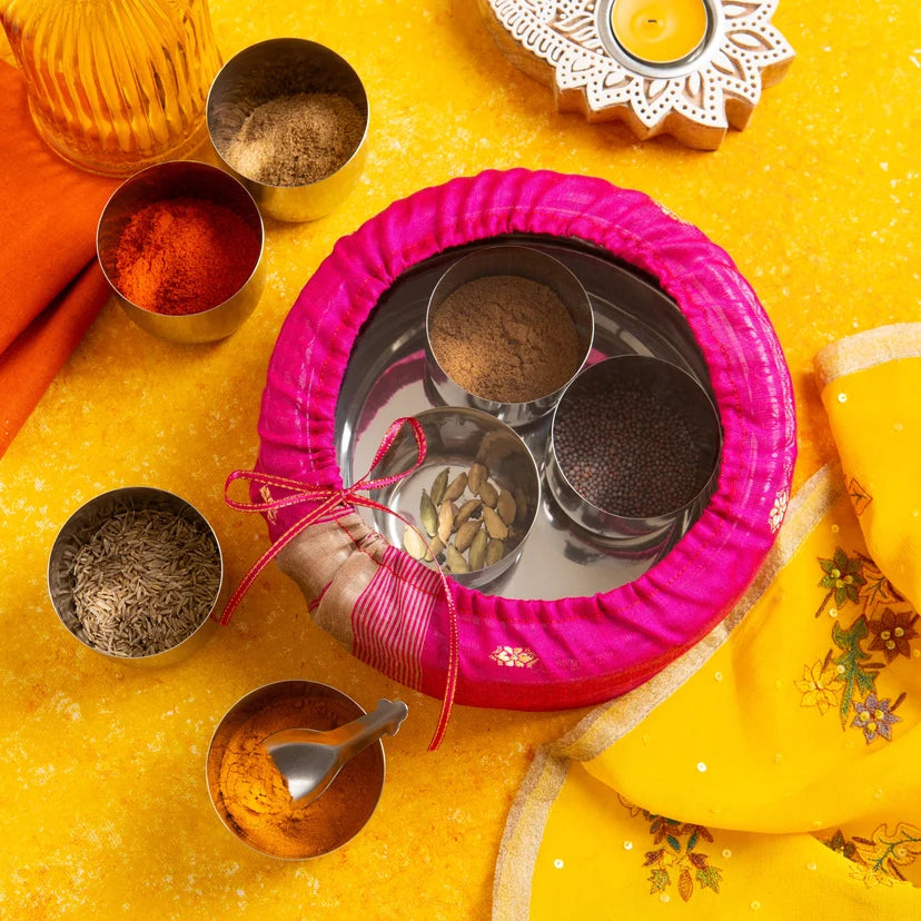 Spices in small bowls with a pink lid on a yellow background