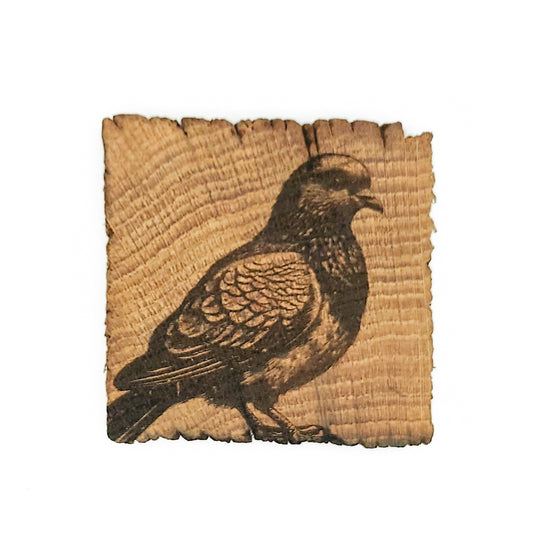 Wooden coaster with an engraving of a pigeon.