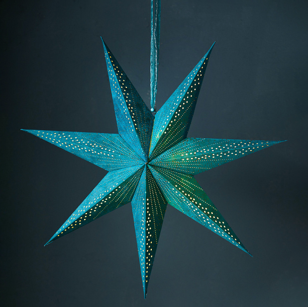 Teal velvet hanging star decoration with light glowing from the inside. Photographed against a darer teal background.