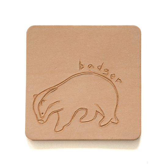 Beige leather coaster with engraving of a badger