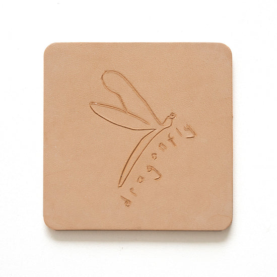 Beige leather coaster with engraving of a dragonfly