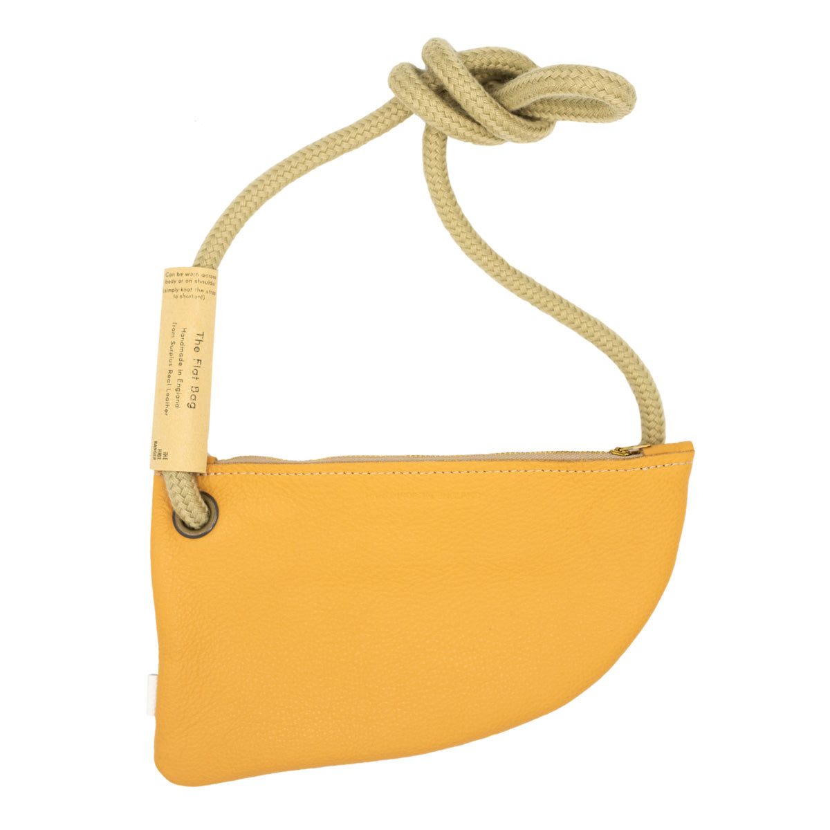 A mustard-yellow leather crossbody bag with a rope strap. The bag has a curved shape and a zipper closure. A tag is attached to the strap reads with product info.