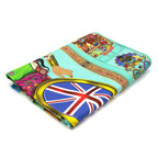 Singh Twins Brittasia design tea towel, folded into 1 quarter.. Blue background and person sat in a wheelchair with the British flag for the wheel. 
