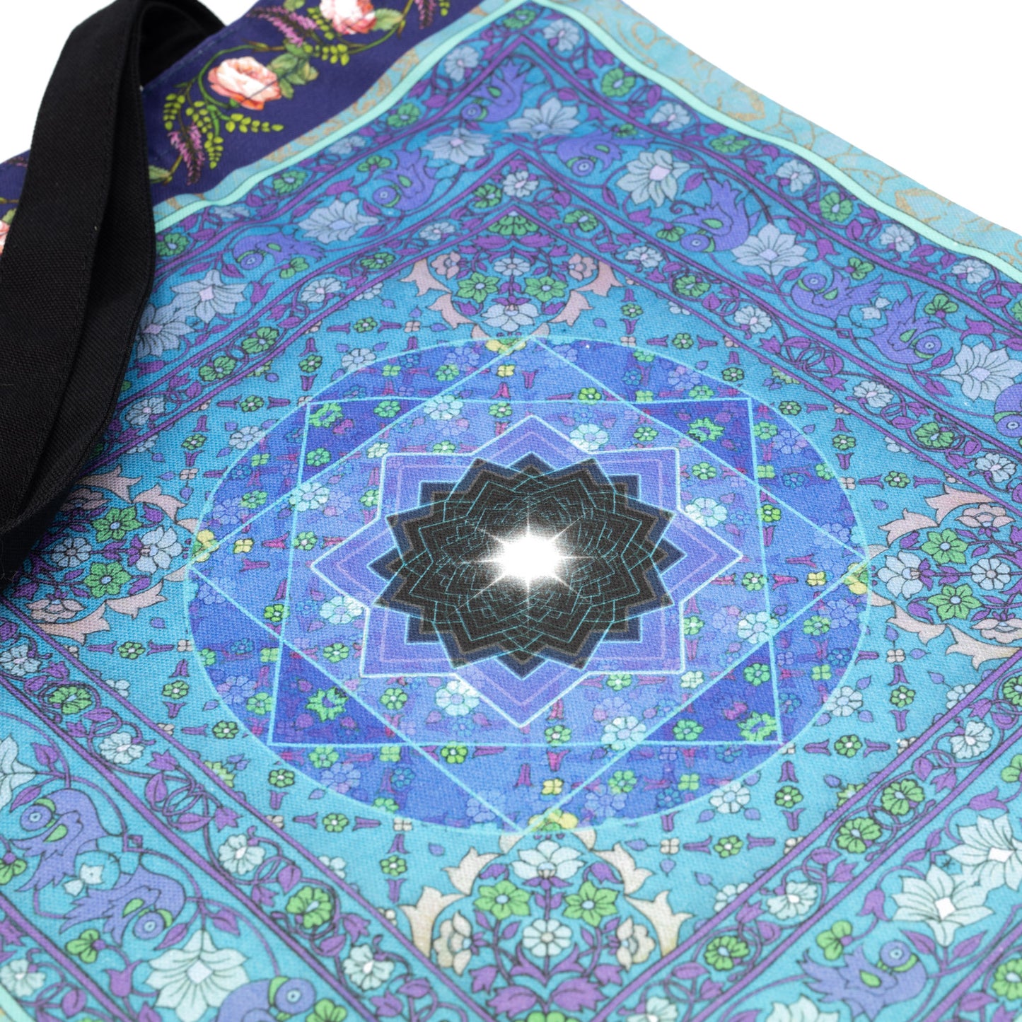 Back of Singh Twins Knowledge Design Tote Bag. Geometric shape at the centre of a blue and green floral pattern.