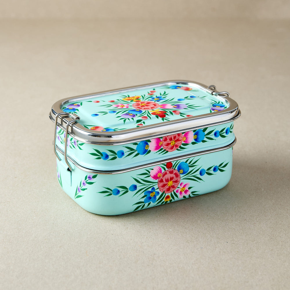 Tiffin lunch box with floral design on a beige background