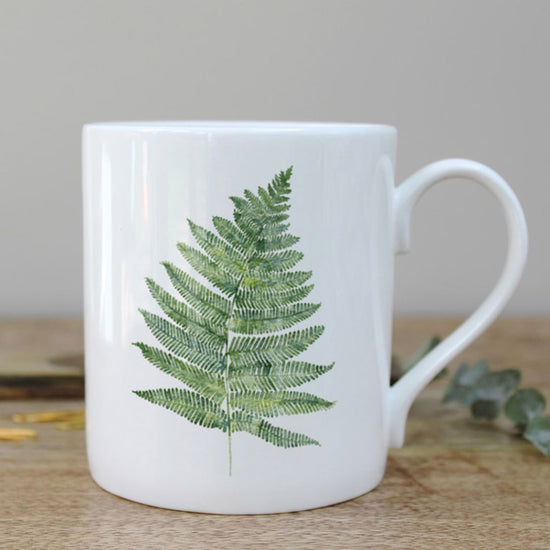 White mug with a watercolour illustration of a fern leaf